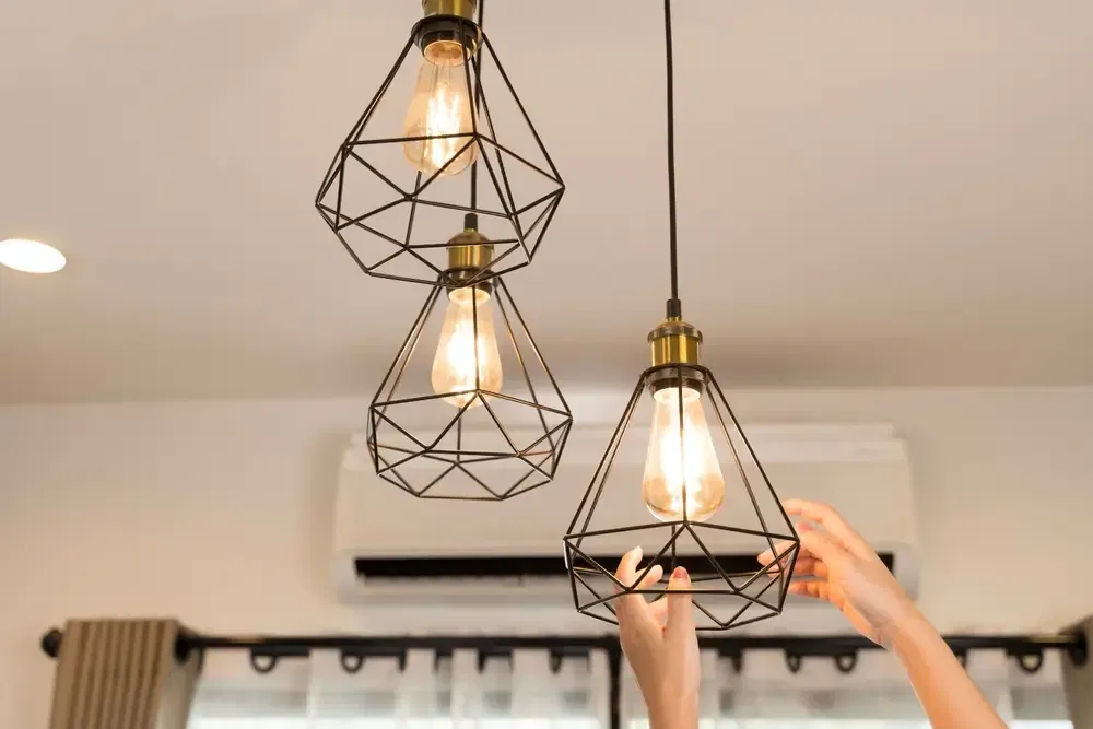 Gros plan mains ajustant ampoule pendentif dans la maison moderne pour la décoration éclairage intérieur efficacité énergétique design élégant inspiration atmosphère chaude style de vie créatif luminosité confort concept.