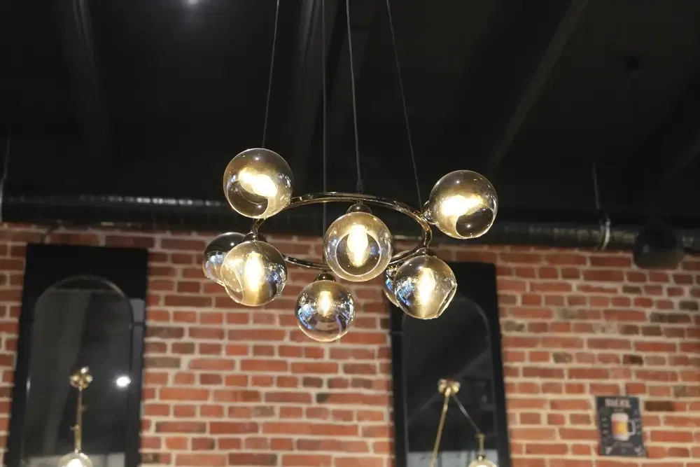 Belles lampes élégantes suspendues au plafond dans une salle à l'éclairage chaleureux, lumière agréable et agréable, salle de restaurant élégante, décor de chambre calme et décoré de lumières ambiantes.