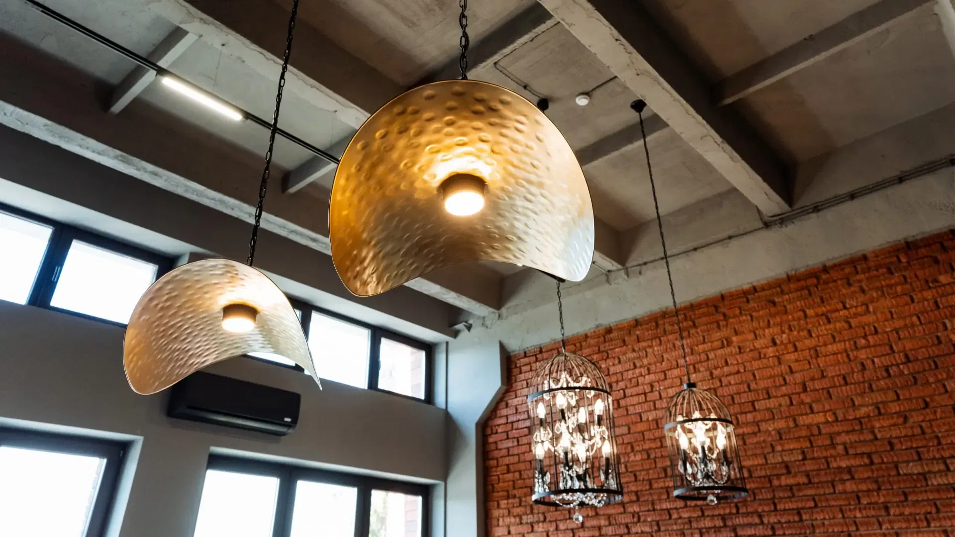 Le loft industriel présente des lampes suspendues artistiques, un design tissé, des murs en briques apparentes et de grandes fenêtres, créant une ambiance design et contemporaine avec une touche moderne et branchée.
