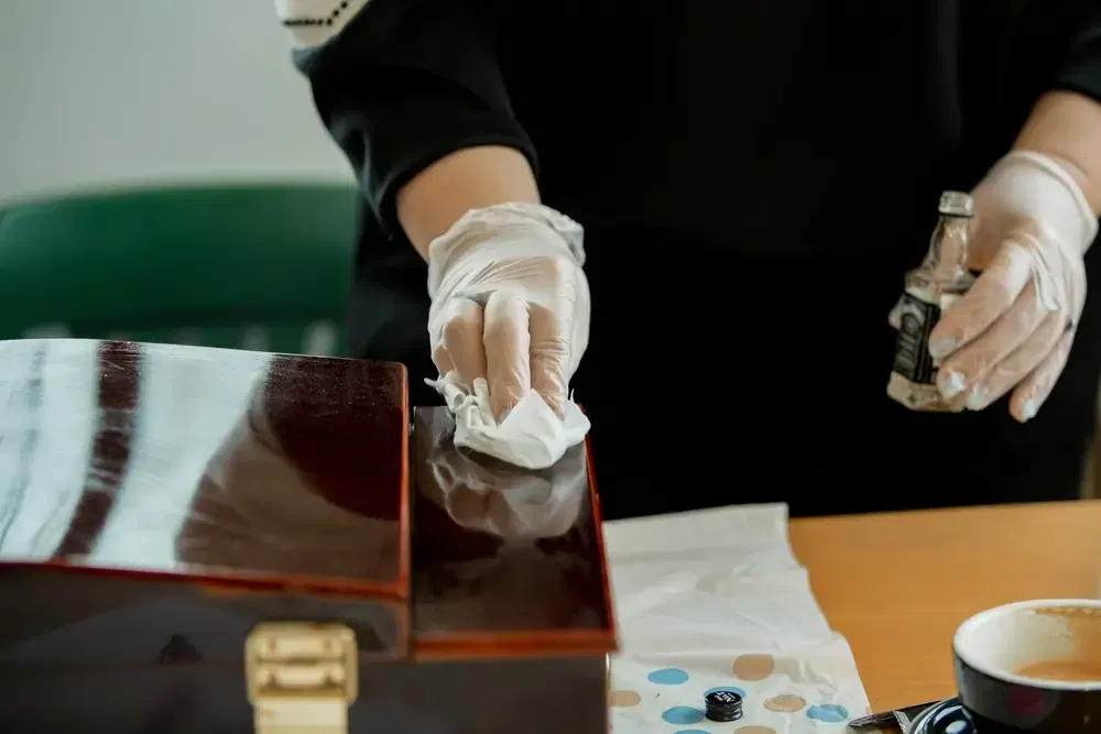 Les mains des femmes en gants préparent la surface en bois pour la peinture, le dégraissage.